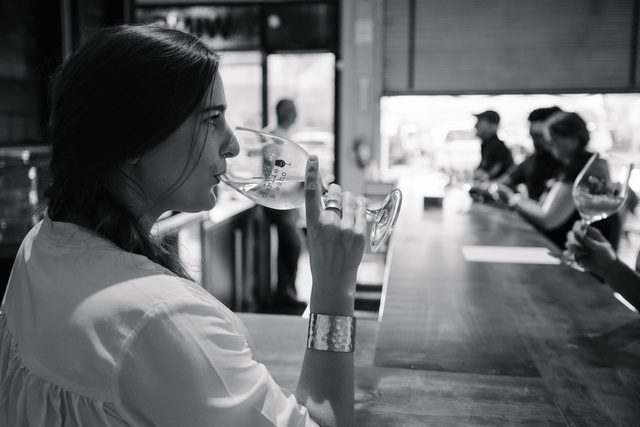 Black and white photo of a woman drinking a glass of wine
