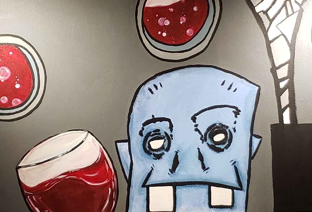 Mural in tasting room with cartoonish wine drinker.
