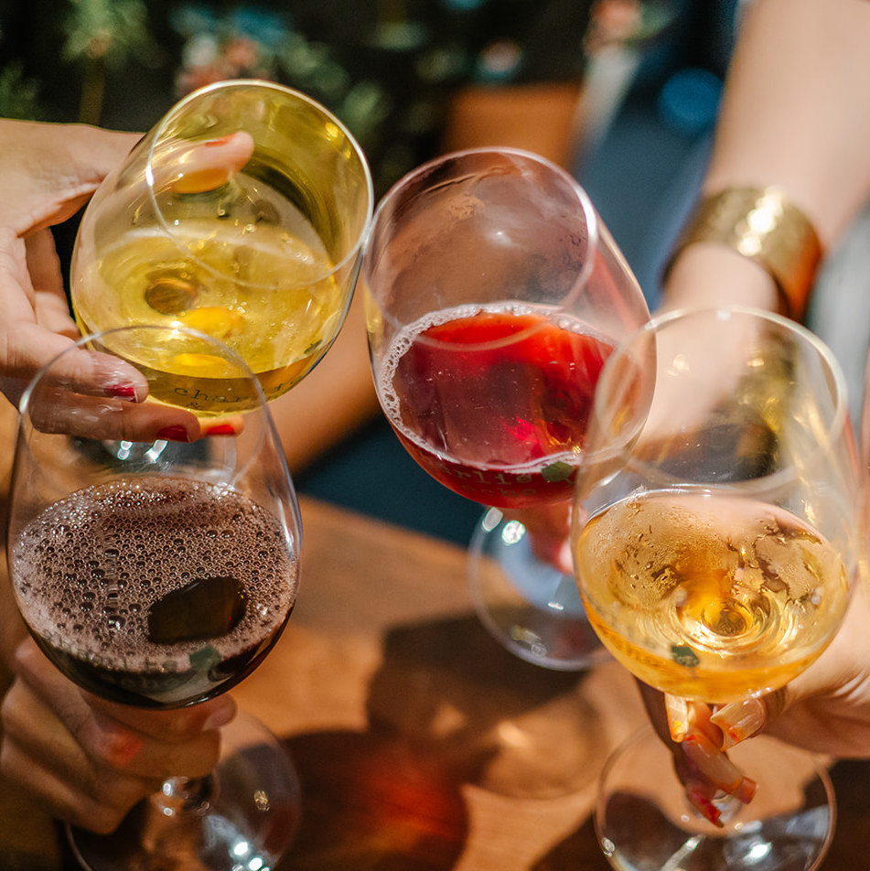 Hands holding up wine glasses giving cheers